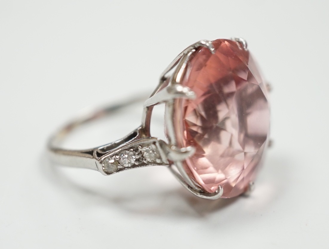 A white metal and circular cut pink tourmaline set dress ring, with three stone graduated diamond set shoulders, size I/J, gross weight 6.6 grams
